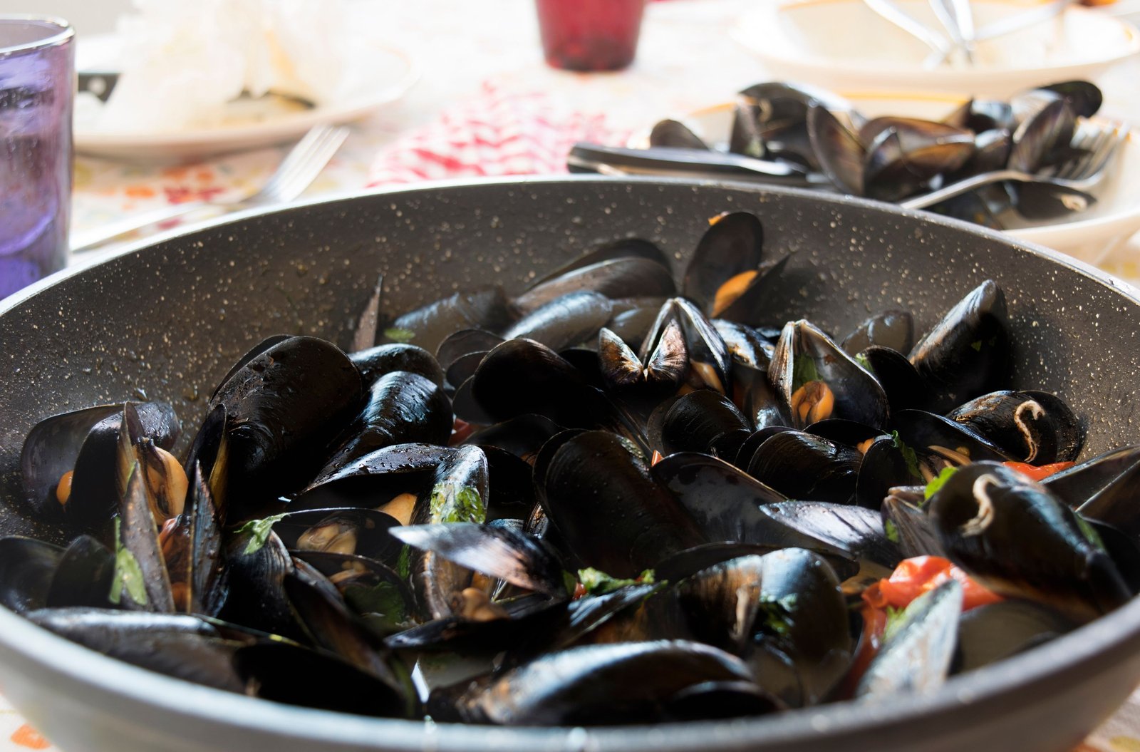 Padella di cozze appena aperte servita al tavolo