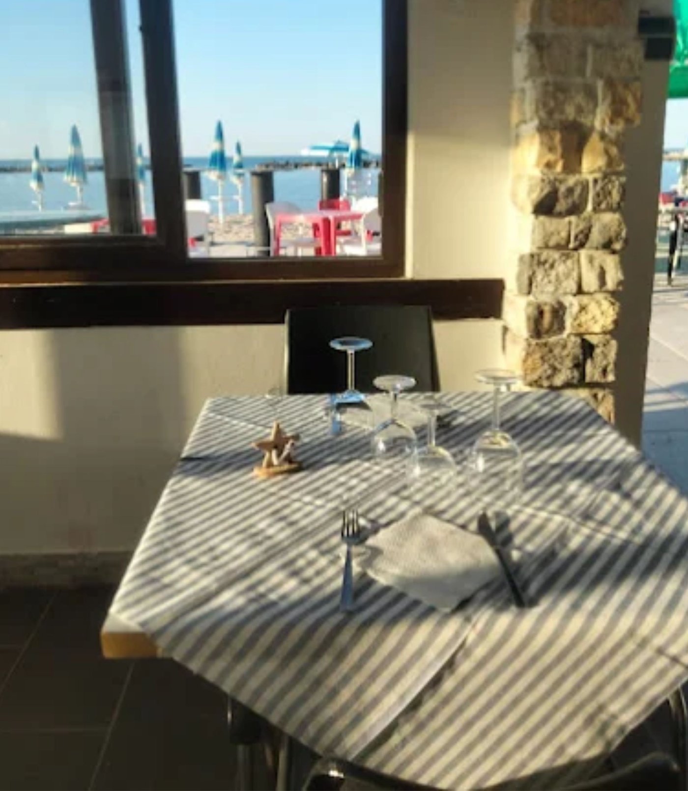 Tavolo apparecchiato nella sala con vista sulla spiaggia